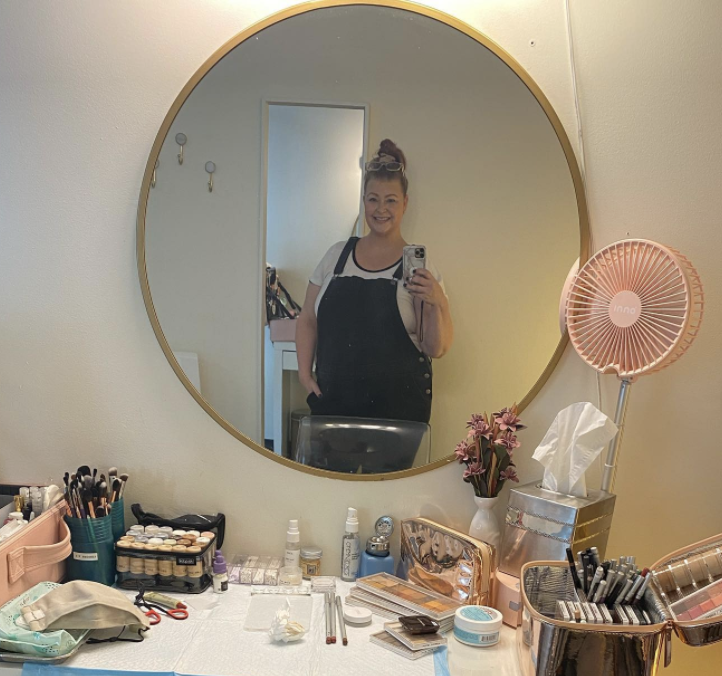 Makeup artist and gear in front of mirror